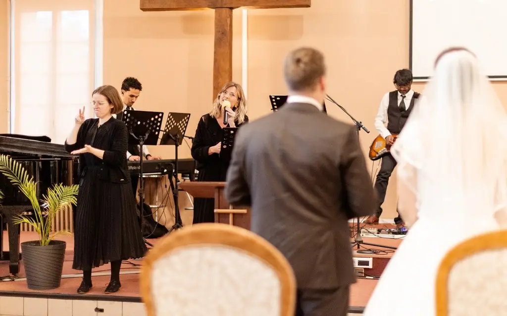 L'interprète traduit en langue des signes une cérémonie de mariage avec des chants religieux.