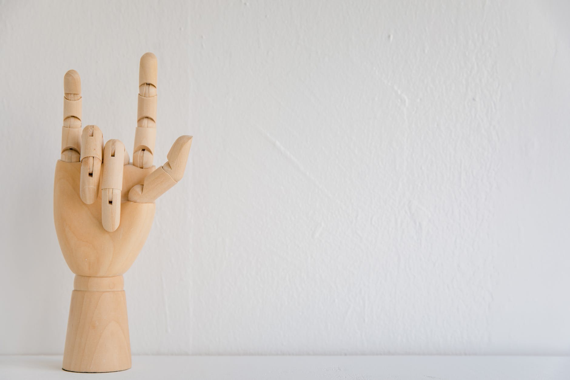 studio shot of wooden hand showing sign language